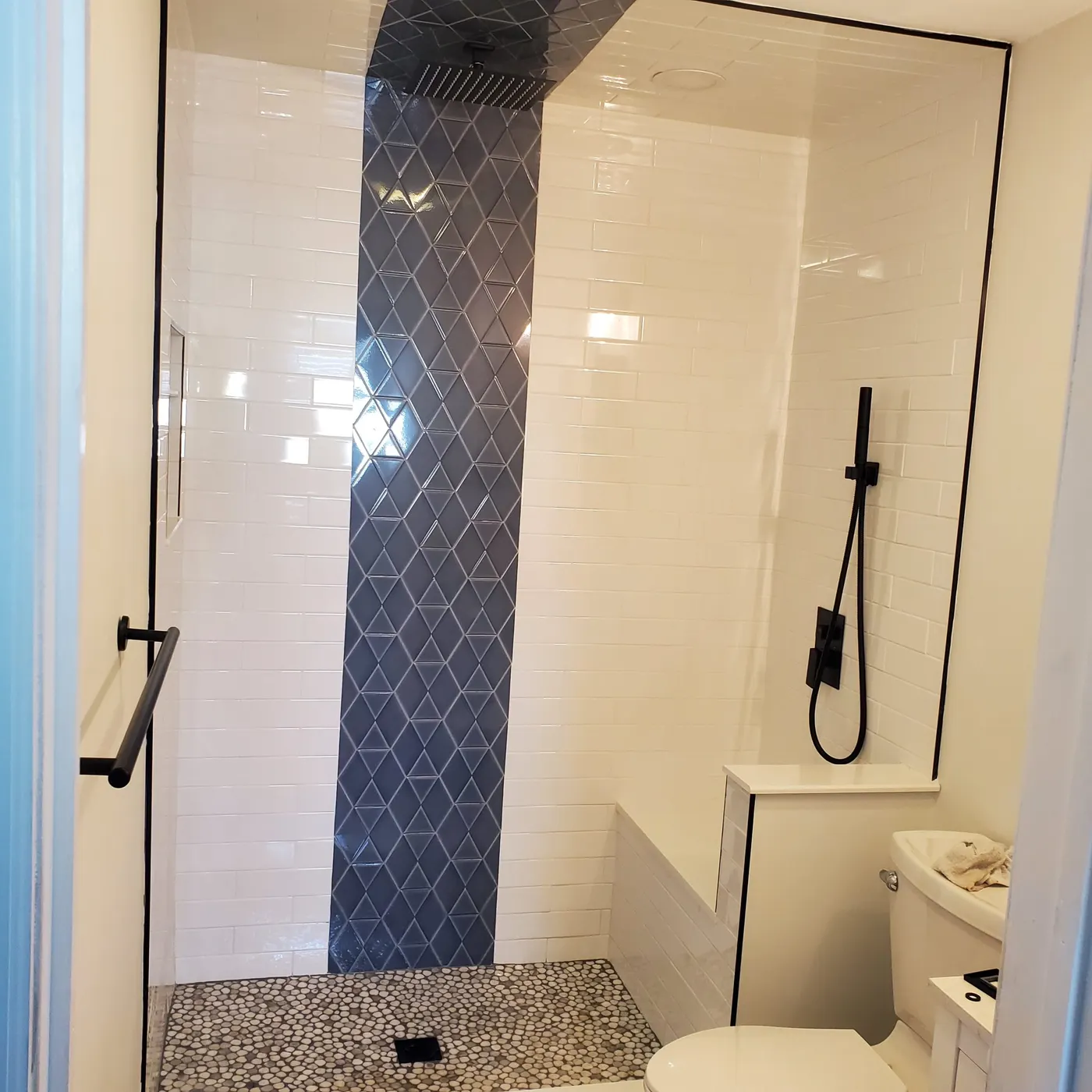 Walk-in shower with blue diamond accent tile and rain head