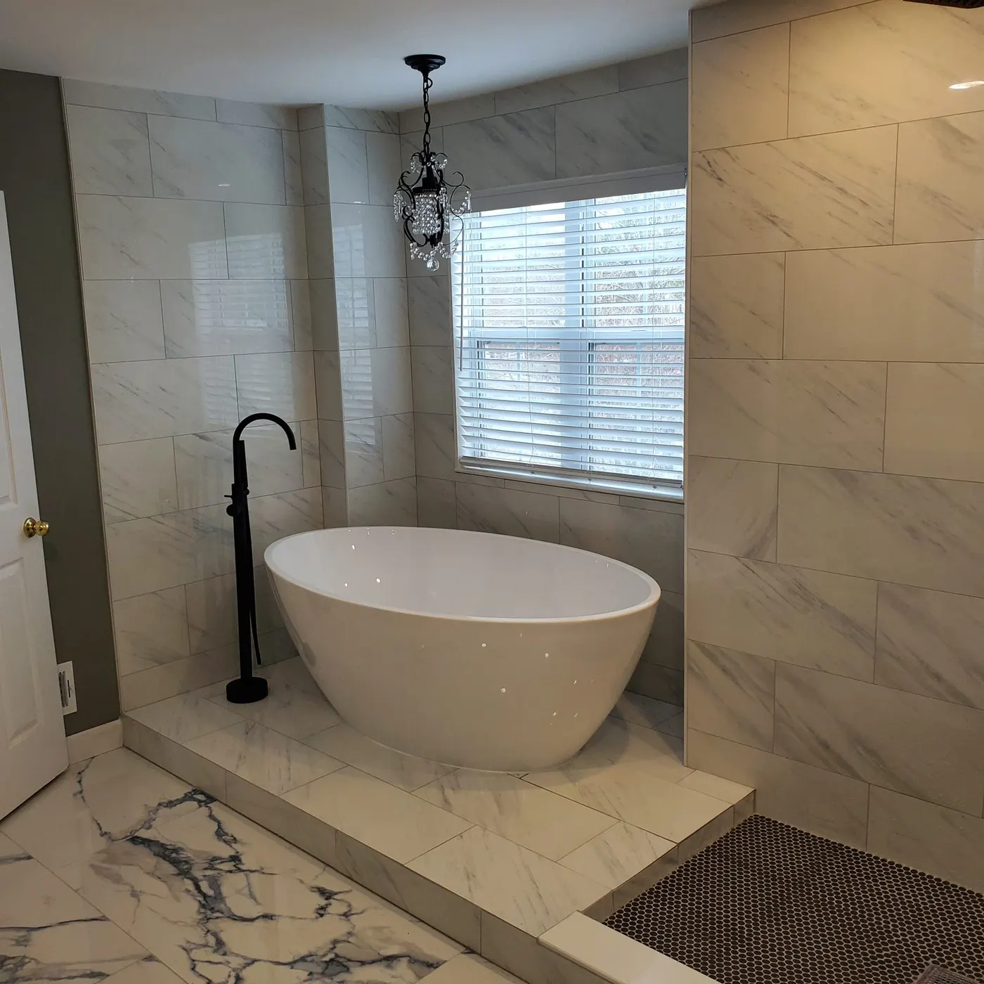 Freestanding soaking tub with floor-mounted matte black filler